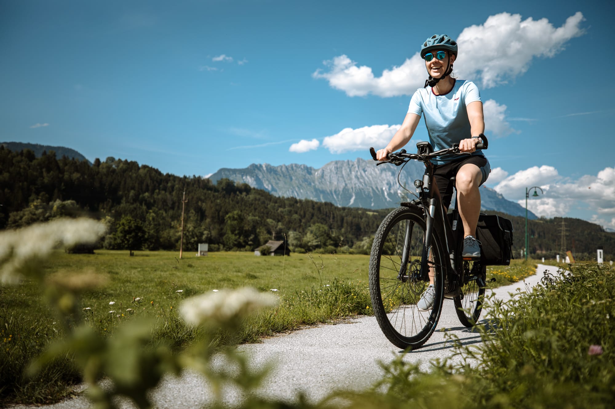 frau auf fahrrad vor bergen in österreich