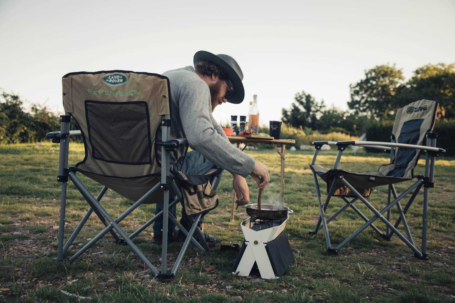 campingurlaub Rügen: Ein Mann sitzt auf einem Stuhl und kocht