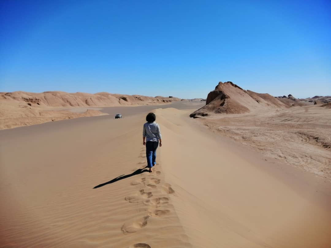 Frau läuft barfuß in der Wüste