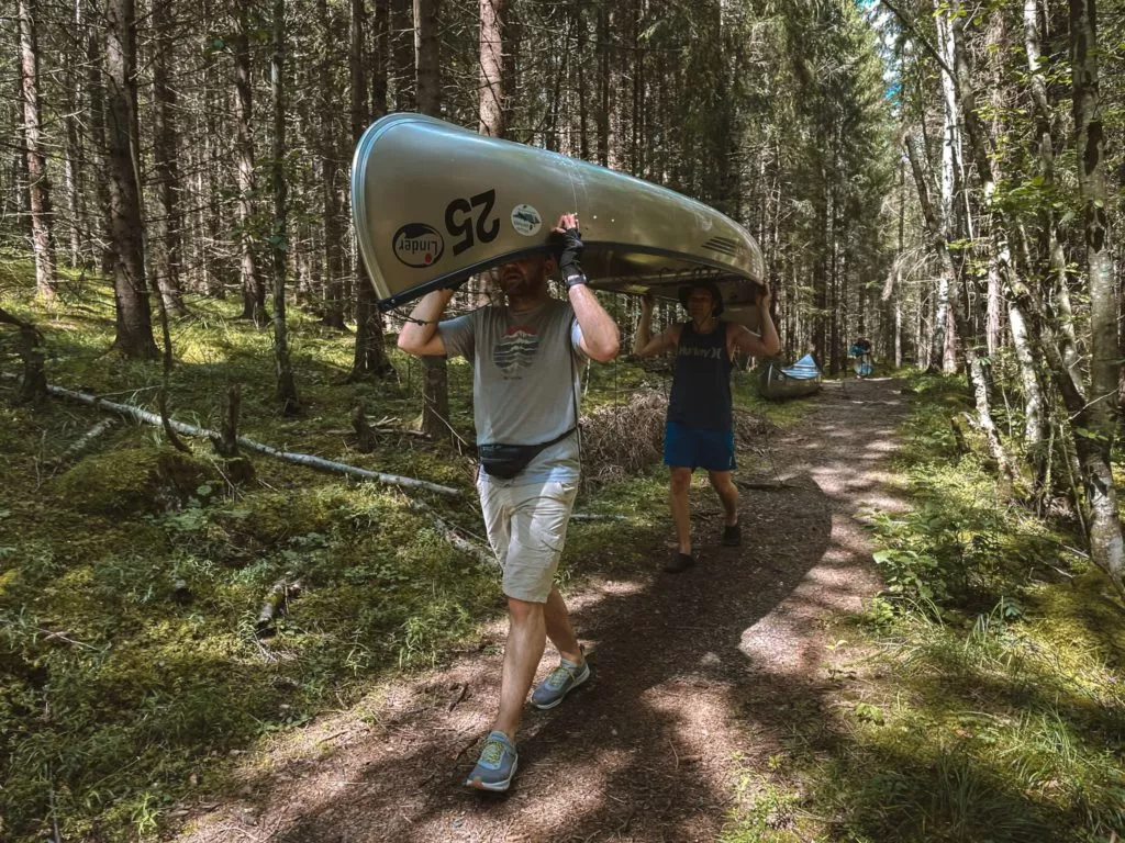 Kanutour Schweden Zwei Männer tragen Kanu über Kopf