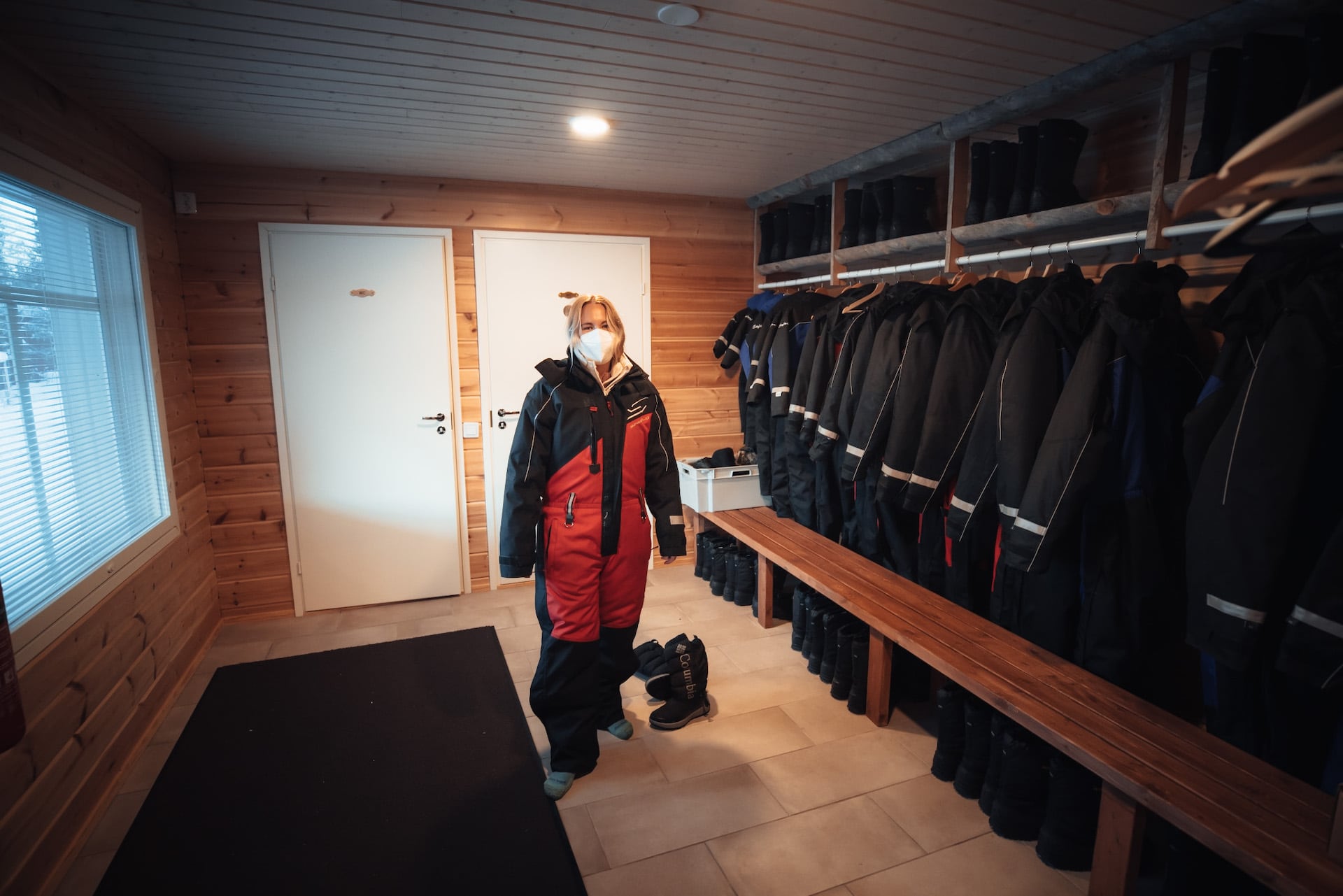 Frau probiert Schneeanzug auf Huskyfarm in Finnland an