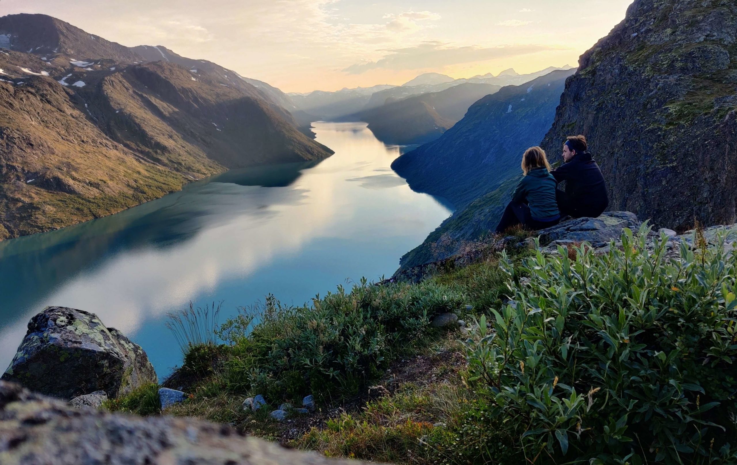 Zwei Leute blicken auf einen See im Gebirge Norwegen