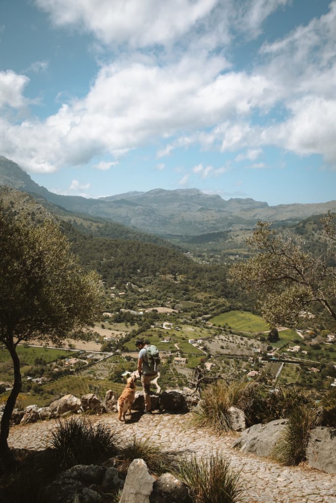 Mann wandert mit seinem Hund auf Mallorca