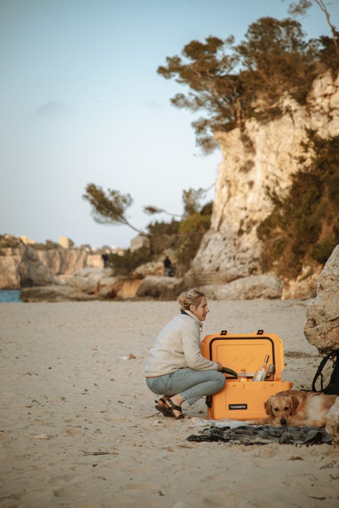 Frau mit ihrem Hund an einem Strand auf Mallorca