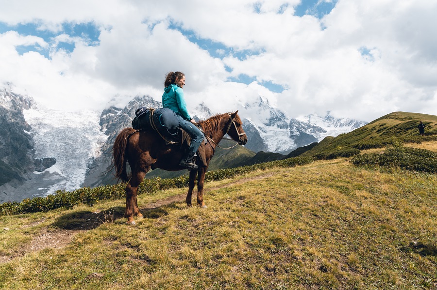 Frau auf Pferd in den Bergen Georgiens