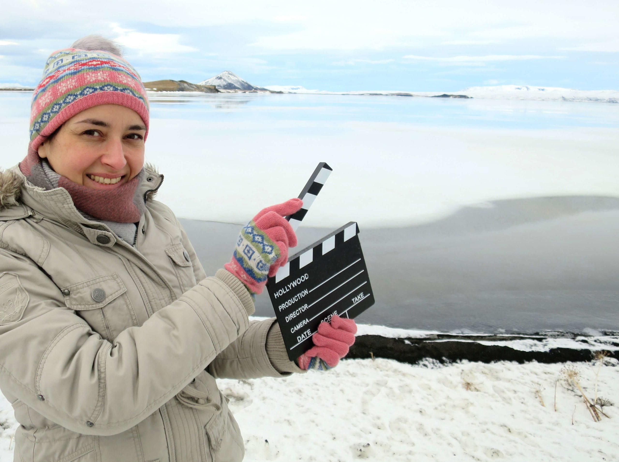 Frau in Island mit Filmklappe im Schnee