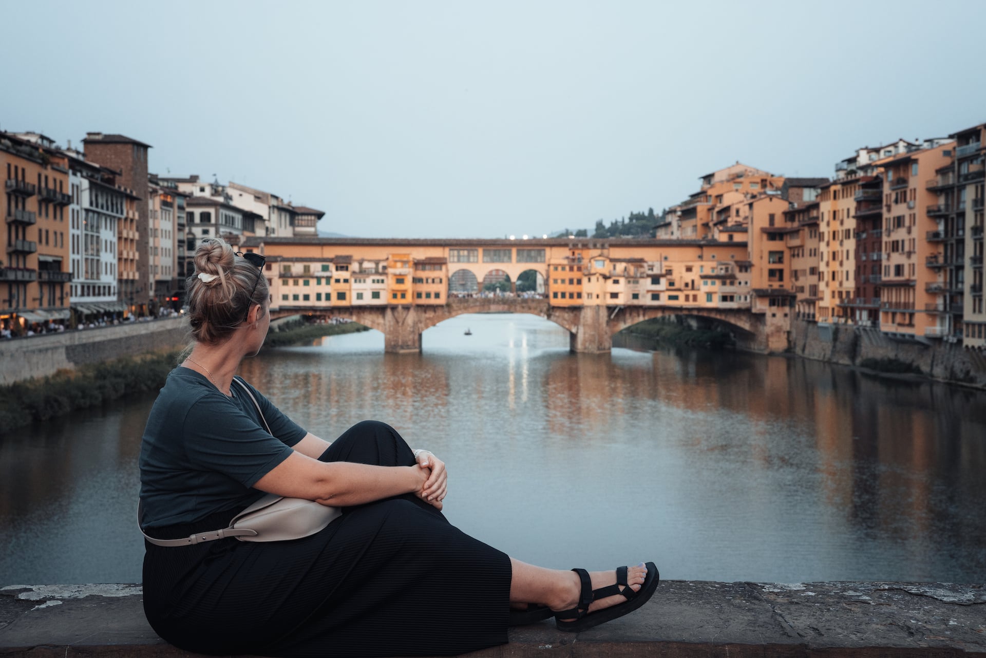 Frau blickt auf die Ponte Vecchio in Florenz