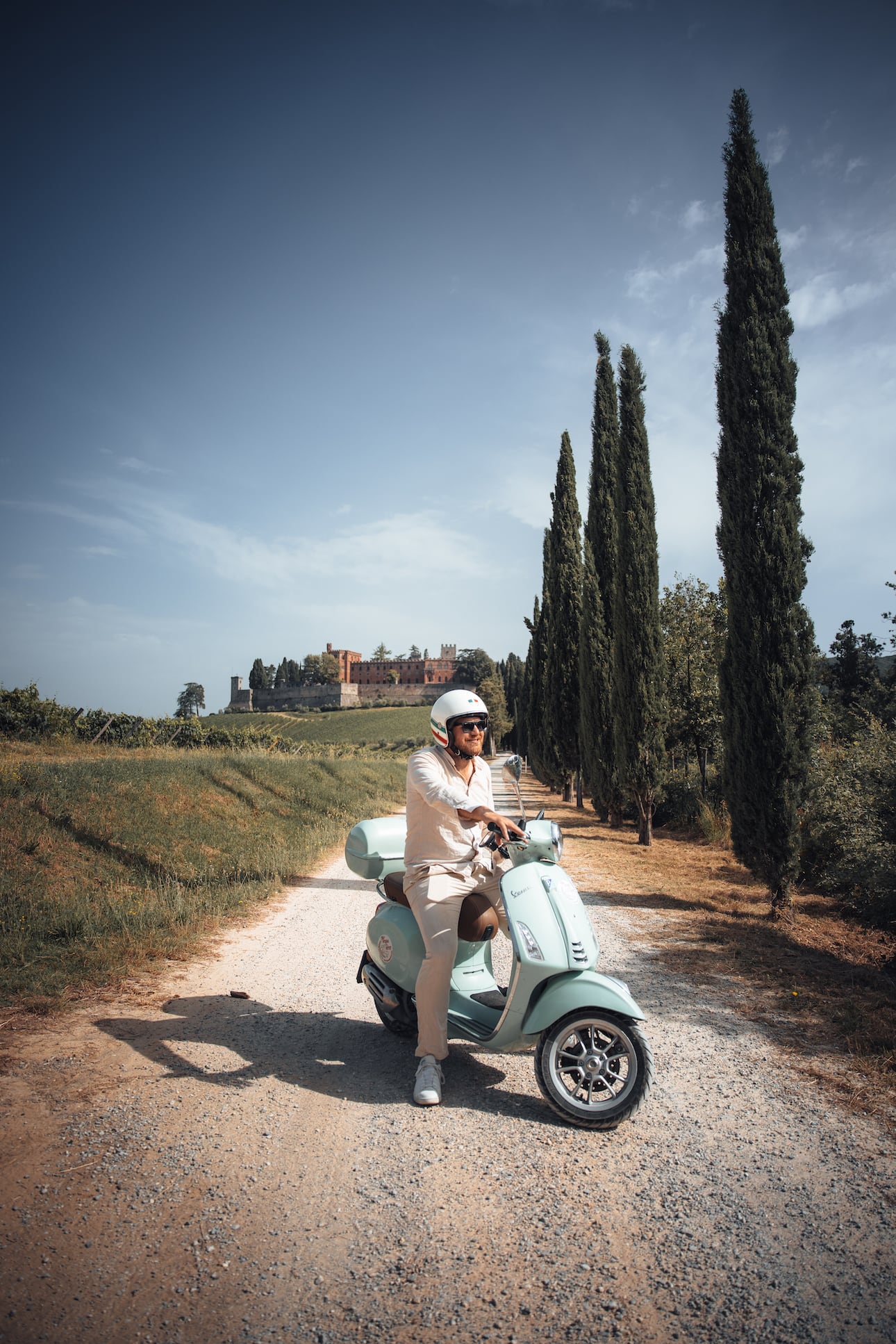Mann vorm Schloss Brolio auf seinem Vespa Trip durch die Toskana