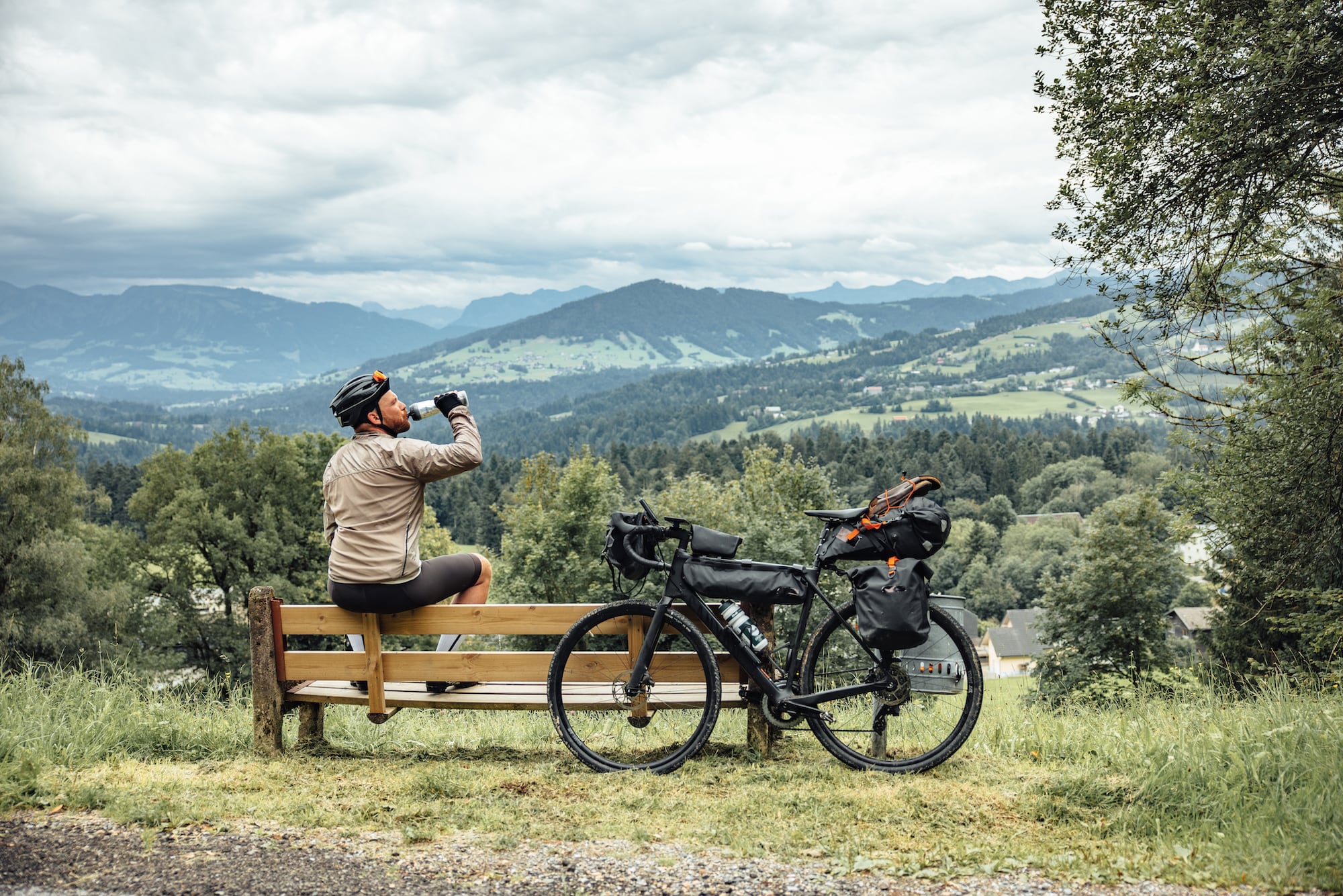 Bikepacker genießt eine Pause mit Aussicht auf Berge in Vorarlberg Österreich