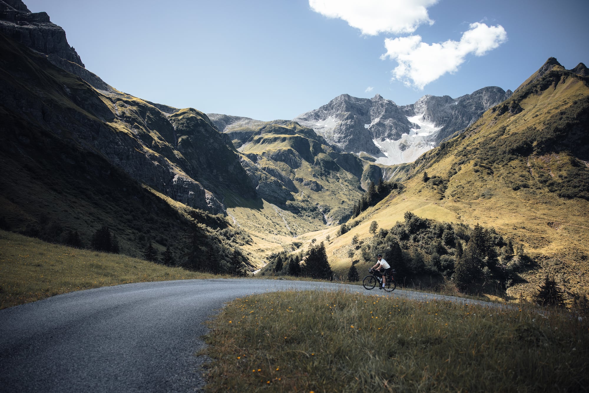 Gavelbiker auf Bickepacking-Tour genießt das Bergpanorama der Auenfelder Alm in Vorarlberg