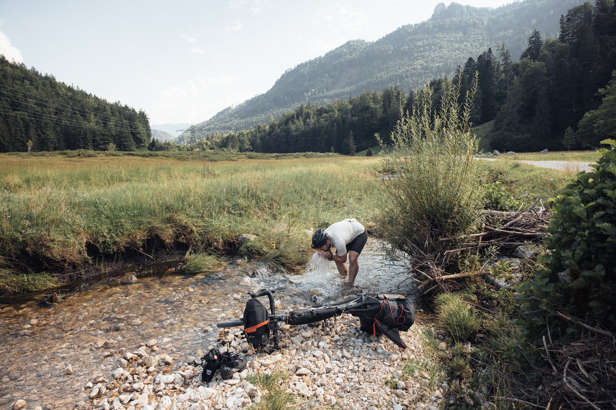 Mann macht Pause auf seiner Gravelbike-Tour durchs Salzkammergut in Österreich