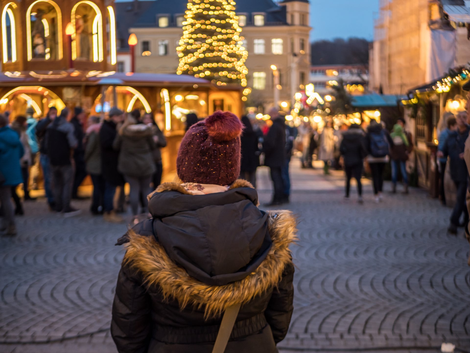Frau schaut auf die Lichterketten vom Christkindlesmarkt in Nürnberg