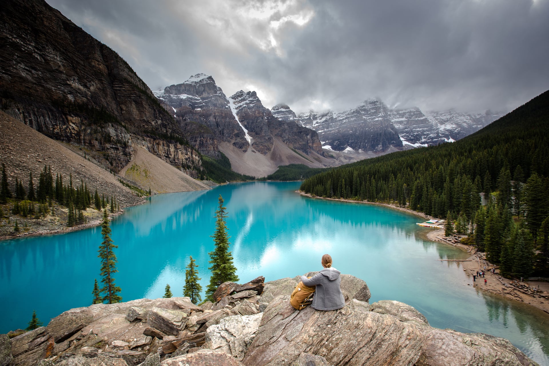 Reisefotografie Tipp: Frau sitzt im Banff Nationalpark und schaut auf den See Morraine Lake