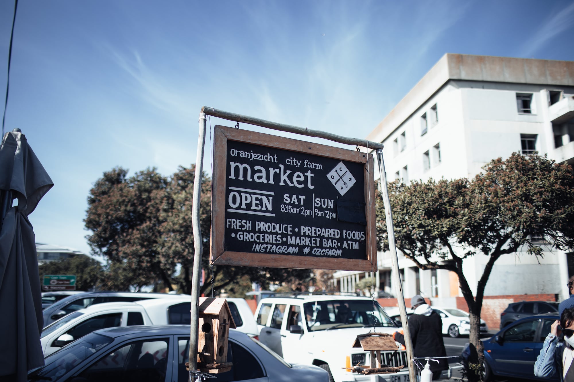Schild mit Öffnungszeiten des Oranjezicht Markets in Kapstadt