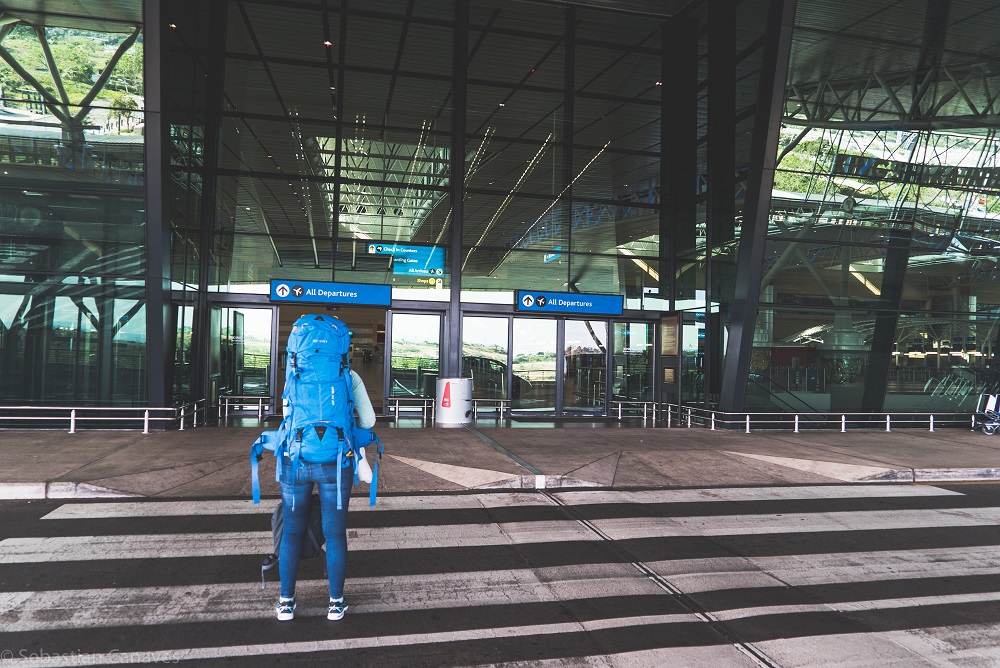 Entschädigung Bei Flugverspätung: Mensch mit Rucksack auf dem Weg in den Flughafen