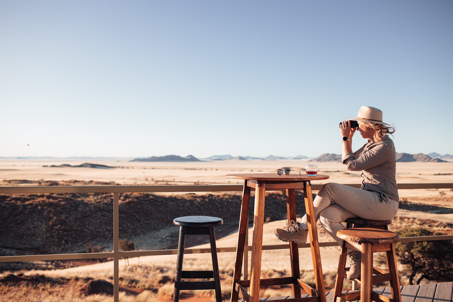 Fotografie Auf Reisen: Frau schaut mit Fernglas in die Wüste Namib