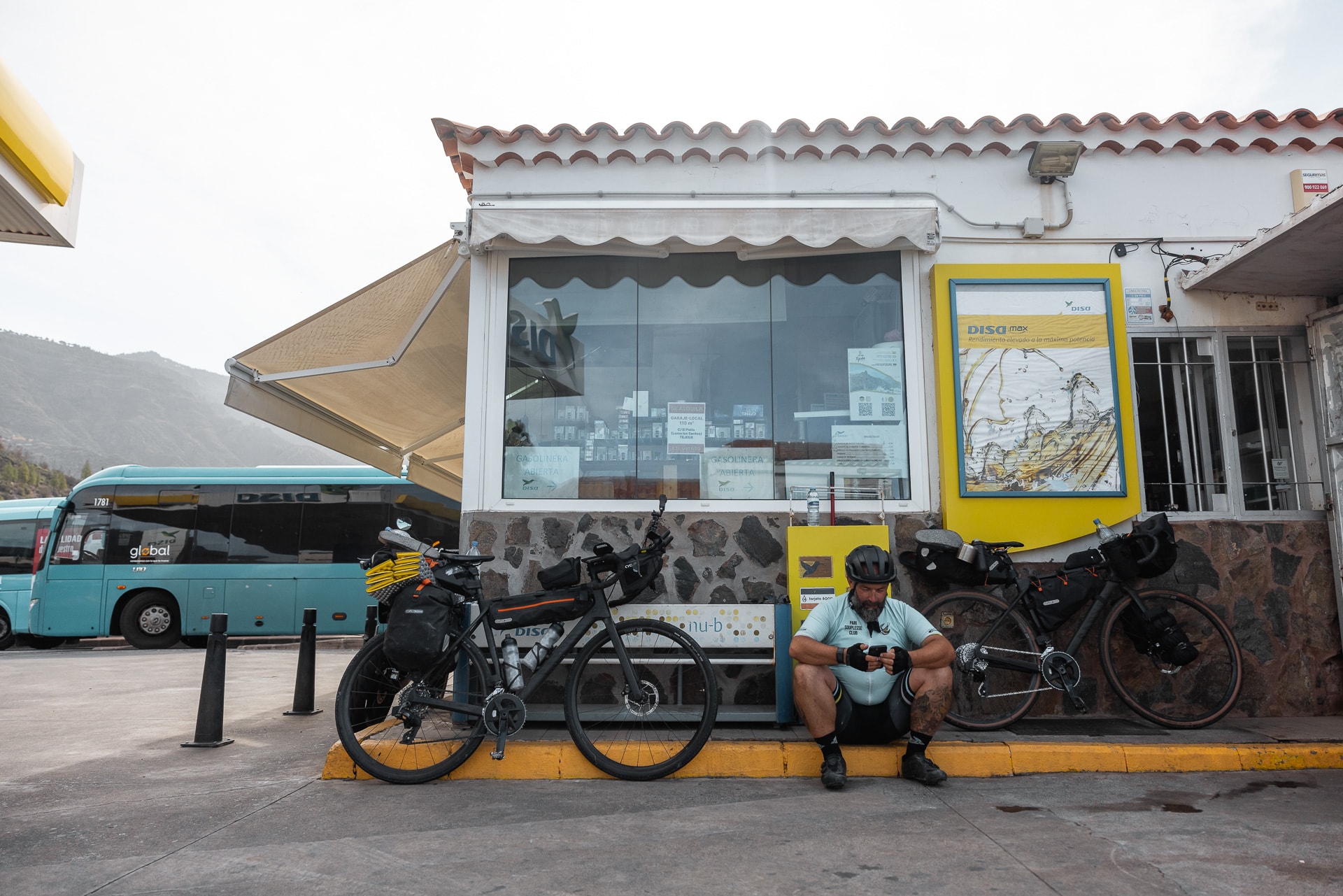 Radfahrer sitzt vor Tankstelle