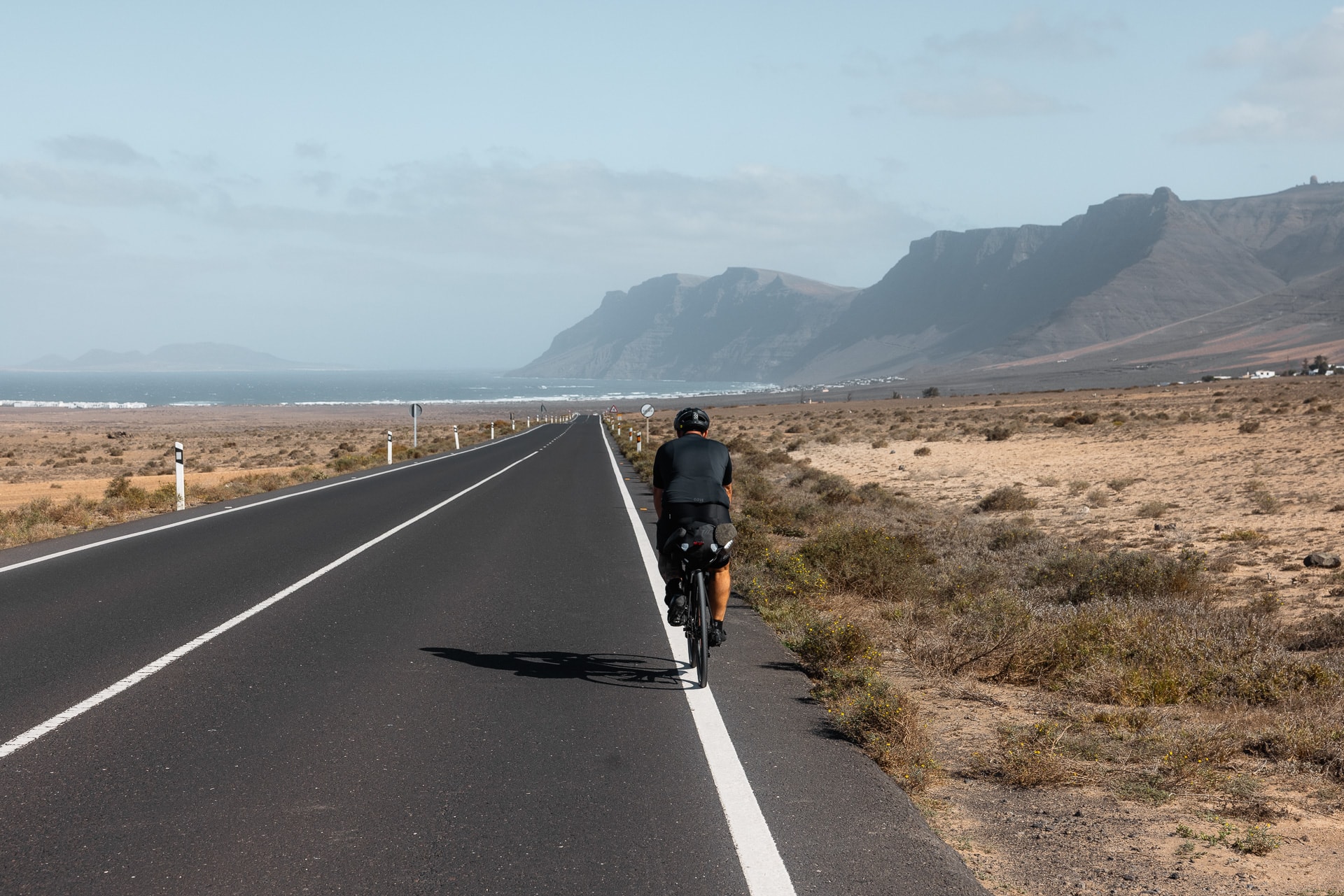 Radfahren auf Lanzarote mit Meer und Berge im Hintergrund