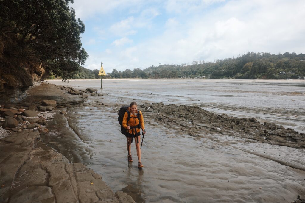 Frau wandert durch eine Flusslandschaft in Neuseeland