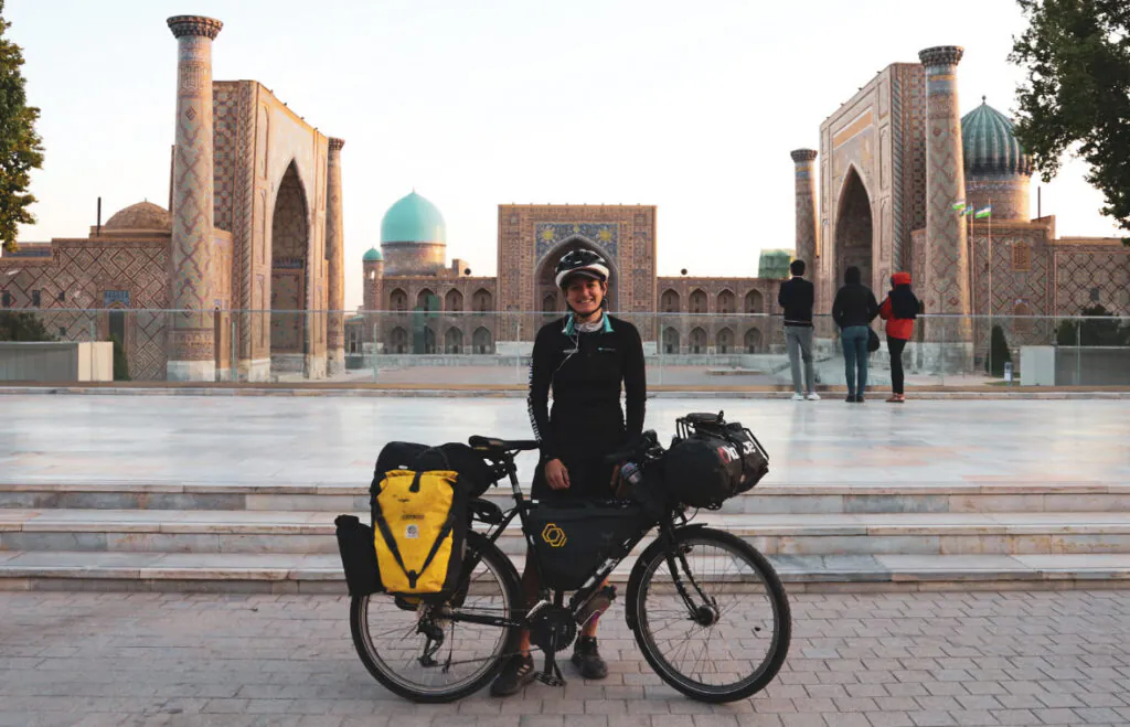 Frau mit Fahrrad und Helm vor dem Registan in Samarkand