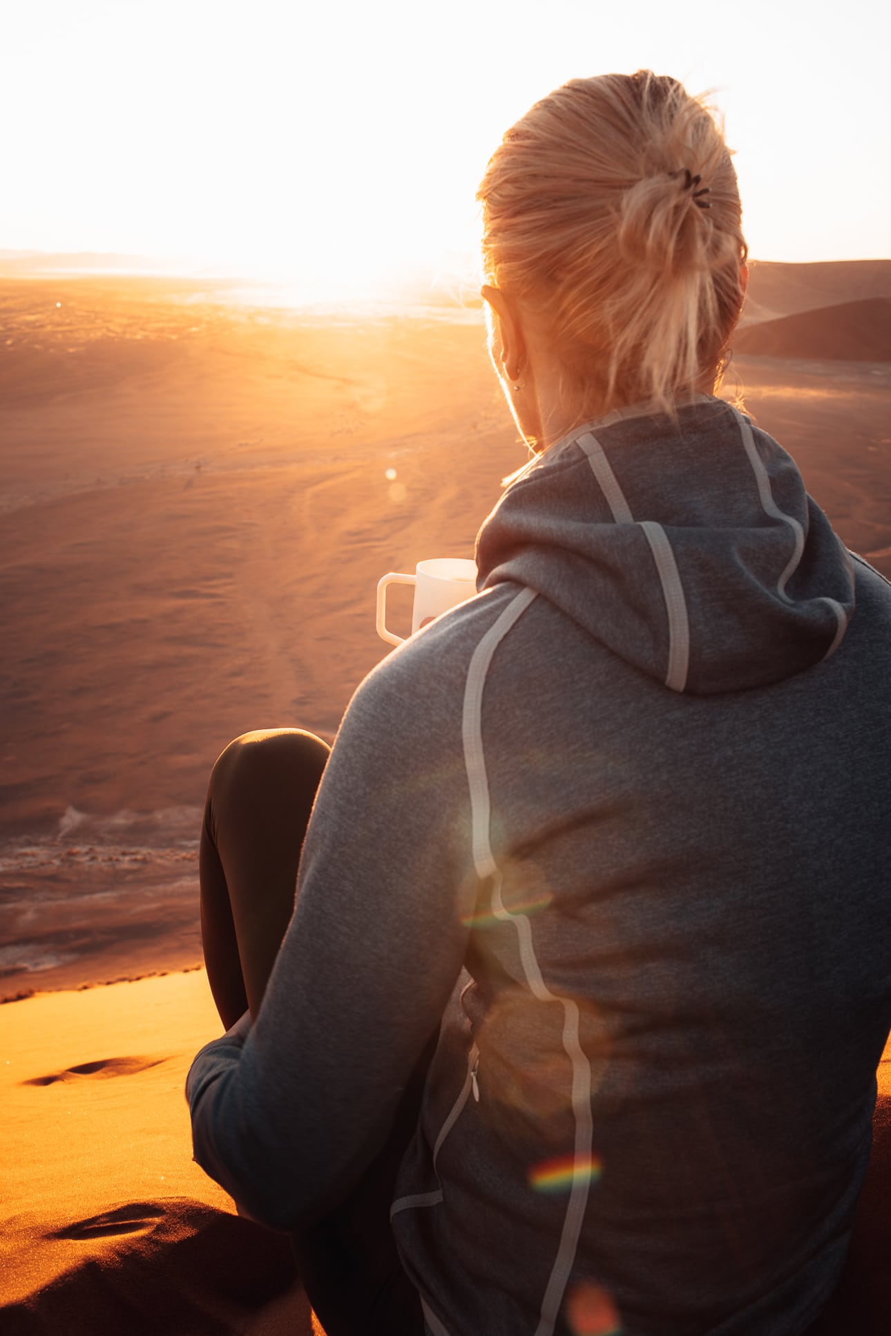 Frau sitzt in der Namib Wüste