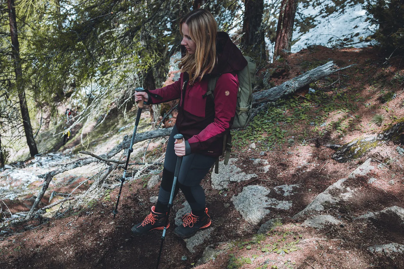 Stöcke mit Anti Schock System sind praktisch: Wanderin mit Stöcken in Berglandschaft