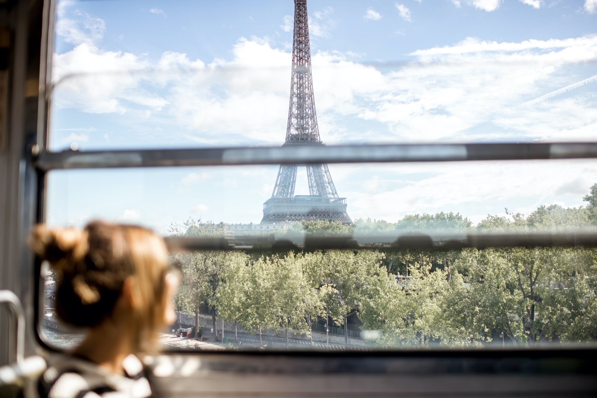 Mit Interrail entdeckst du Orte für deinen Urlaub: Frau schaut aus dem Zugfenster auf den Eiffelturm