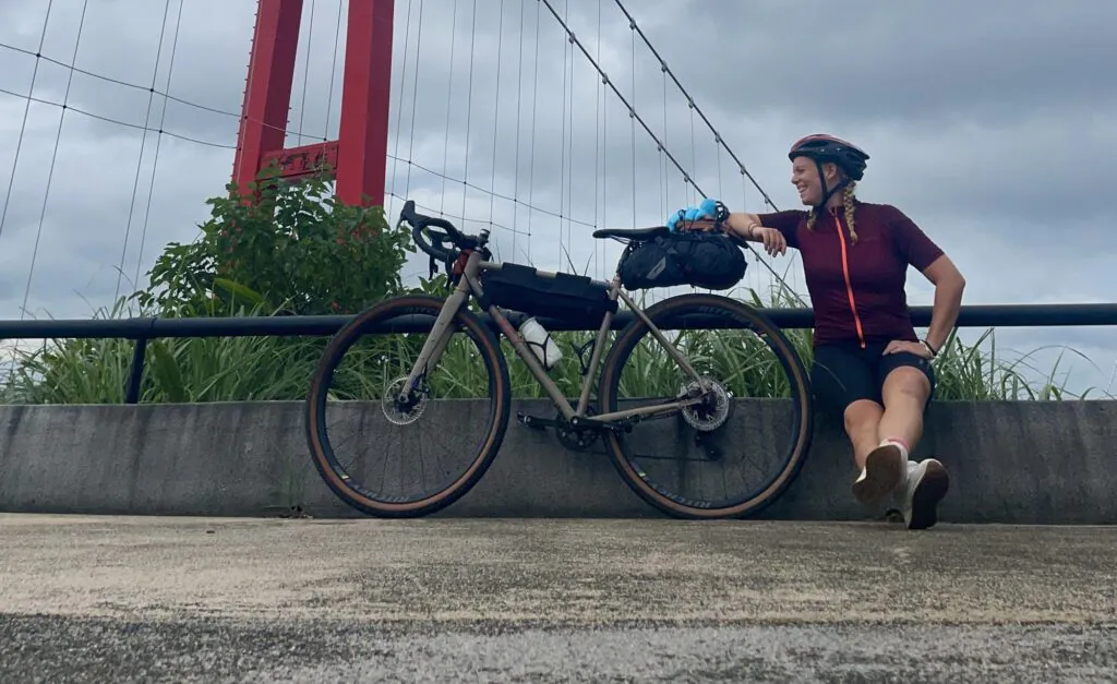 Frau mit Fahrrad vor einer Brücke in Taiwan
