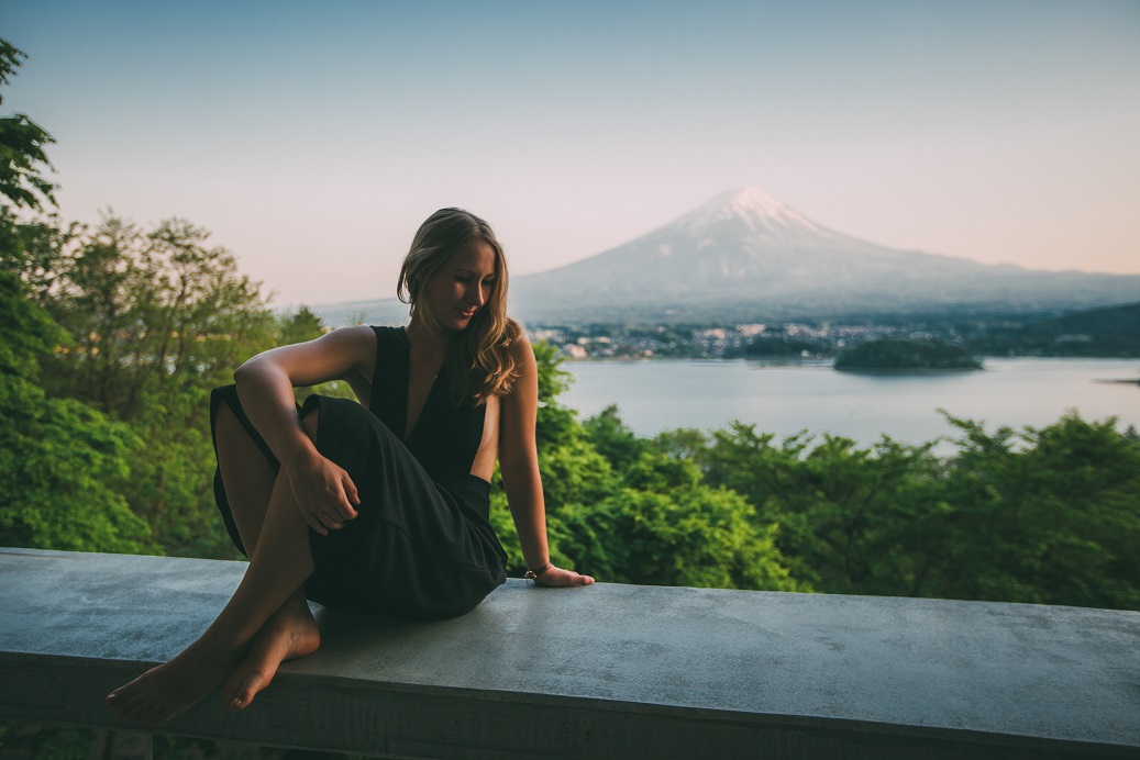 Tipps Abenteuer: Frau sitzt im Urlaub vor einer atemberaubenden Landschaft
