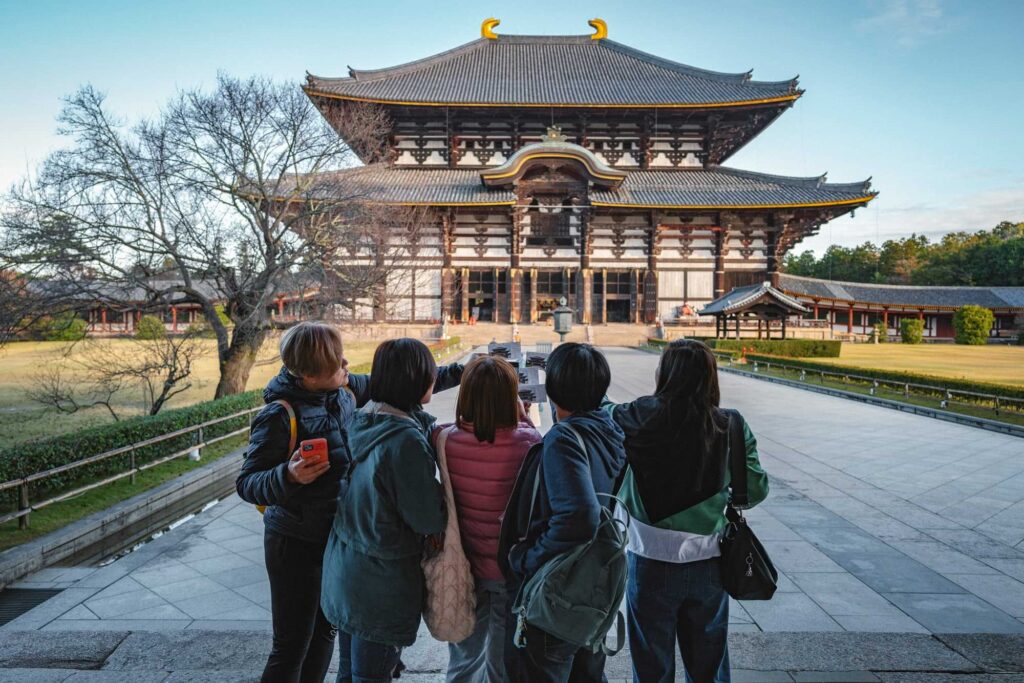 Fünf asiatische Frauen stehen in Japan vor einem Tempel